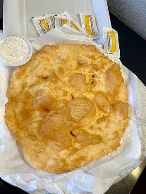 Warm, crisp, tasty frybread with honey and powdered sugar on the side.