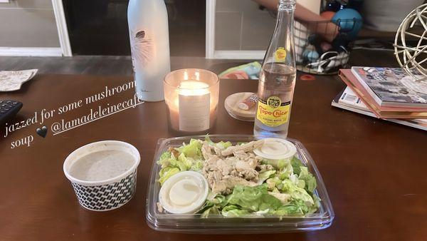 caesar salad and a cup of mushroom soup with a Topo Chico - perfect weeknight dinner delivery!