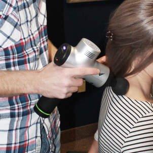 Chiropractor Mike Dumond uses the Hyperice massager to treat neck stiffness