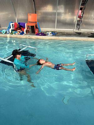 Jonah learning to roll to his back in survival swim class