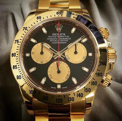 Solid 18 karat yellow gold 2016 Rolex Daytona with the special black and red Paul Newman dial