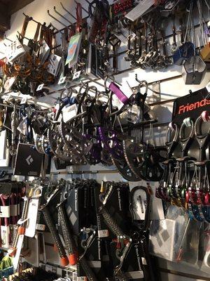 Cams and belay devices on hardware wall.