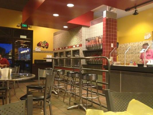 Part of the dining room. Frozen yogurt machines and toppings along the wall.