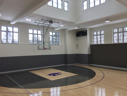 Custom Home Gym featuring Resilient Maple Gym Flooring, Custom Floor Stain with K-State Logo, IPI Ceiling Mount Retractable Hoops