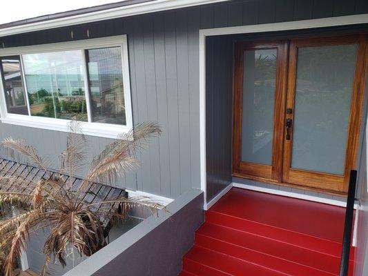 Refinished stained front entry door with red accent steps.