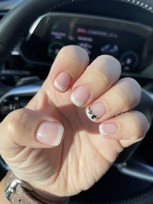 Nextgen, glitter tip French manicure with black bow detail.