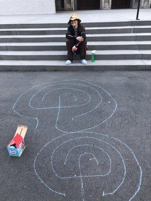 A volunteer shows folks how to draw their own chalk labyrinth