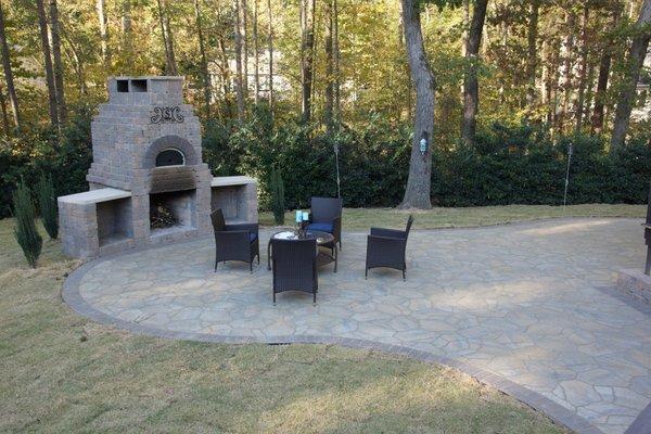 Custom fireplace with pizza oven above. Belgard paver patio.