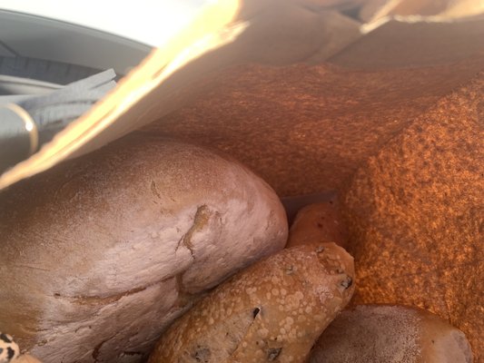 Loaf of seeded bread and small cheese bread and olive bread