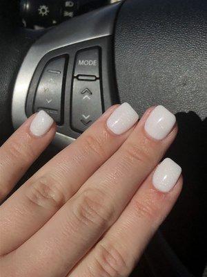 White shimmer dip (D134) on real nails in squoval shape in sunlight