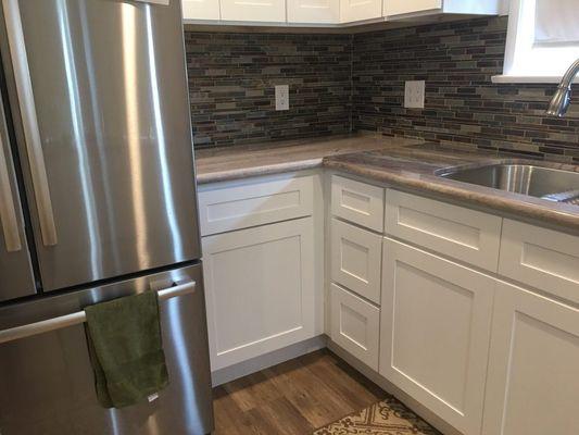 White Shaker cabinetry with granite counter top and undermount sink.