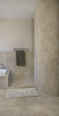 Tile work is highlighted in this bathroom with a rounded shower wall.