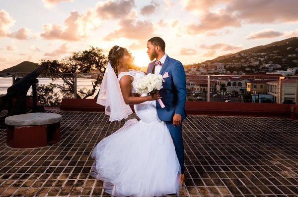 Young couple enjoying an intimate moment during wedding ceremony as the sun sets behind them