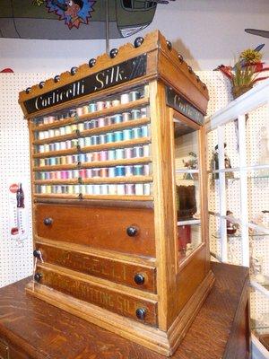 Beautiful castle-style Corticelli Silk Thread cabinet circa 1880's, 6 glass-fronted drawers and 3 solid-pull drawers, mirros on both sides.