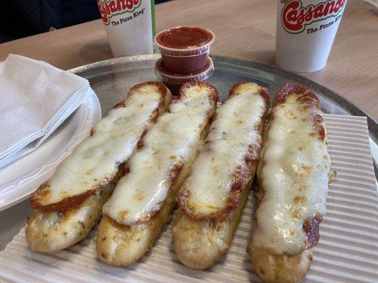 Pepperoni lined up meticulously on cheesy breadsticks