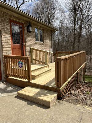 Deck board replacement project with improved platform steps leading to entrance