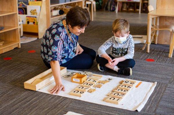 A preschool student receives a lesson on the units of ten using tactile materials designed by Dr. Maria Montessori.