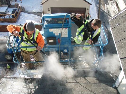 Commercial ice dam removal using a lift in Saint Paul, MN.