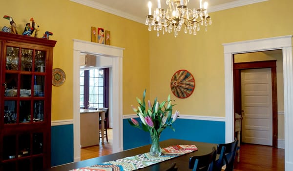 Sunny yellow and teal dining room in historic home.