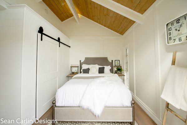 Recessed panel on walls, barn door sliding closet, tongue and groove ceiling.