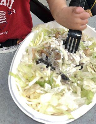 Burrito bowl with brown lettuce, fake cheese and frozen chicken