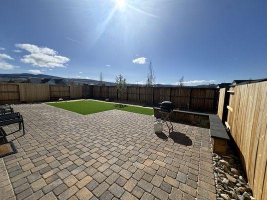 Perfectly matched and extended the pavers to create a larger patio, framed and added artificial grass and planted desert friendly landscape.