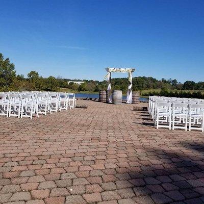 Outdoor Wedding at a local winery featuring white resin padded chairs and whiskey barrels.