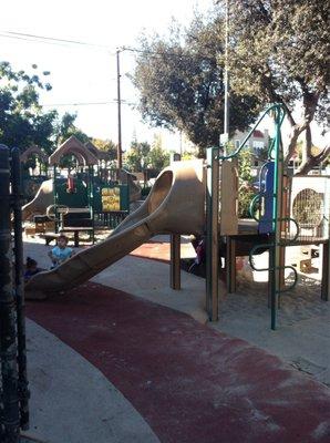 Kids playground area, enclosed with a fence.