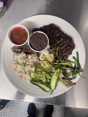 Carne azada-Churrasco Guatemalteco.
New York Steak, ensalada Rusa,aguacate, frijol negro,cebollitas, longaniza chirmol de tomate.