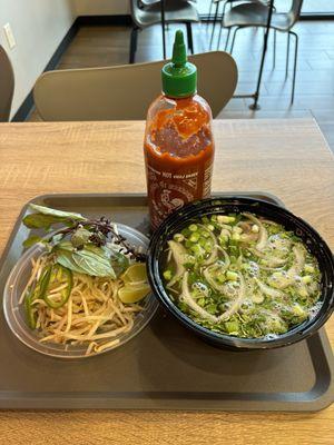 Pho bowl with sriracha bottle for size reference.