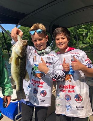 Campers landing a big largemouth bass.