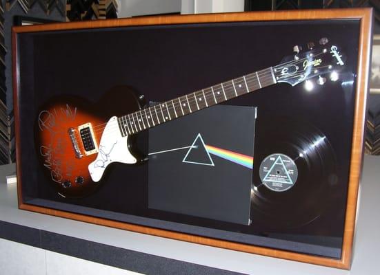 Framed this signed guitar by Roger Waters and Nick Mason, in a 6" shadow box.