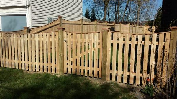 Spaced cedar board and gate with a removable section in Salem MA. Scalloped and capped.