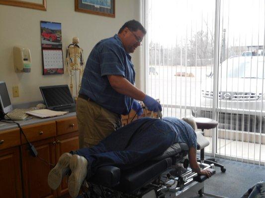 In a treatment room I utilize different Chiropractic Techniques to treat patients.  Here you see me using an Activator on a patients back.