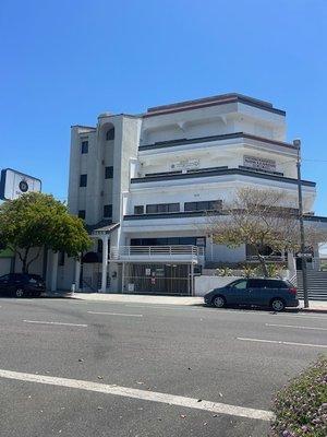 Font of building with plenty of free street parking. Entrance intercom is left of parking garage