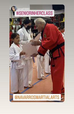 Great Grand Master Carlos Navarro presenting certificates authenticating students new belt ranks.