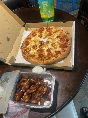 Large pepperoni pizza with pineapples slices barbecue wings and the Sierra mist