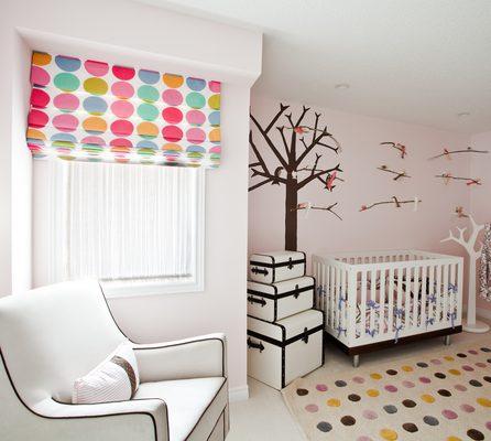 A pop of color adds joy to baby's room.  Decorate with custom roman shades.