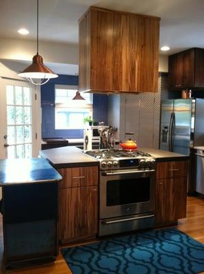 An open kitchen using industrial-inspired surfaces and textures with clean lines in deeper tones, make an interesting and fun...