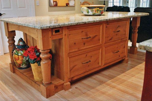 Chunky rustic kitchen island.  Built in knotty alder with heavy turned legs and big drawers for pots and pans.