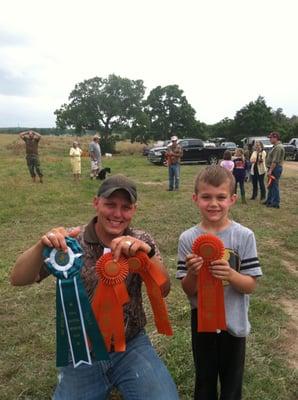 Wade and his son with ribbons won at an AKC hunting competition.