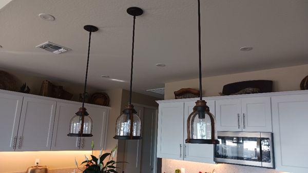 Installed pendulum lights over bar.