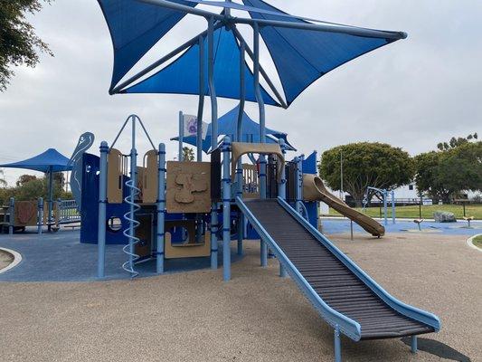 Large Playground with swings, slides, and climbing area