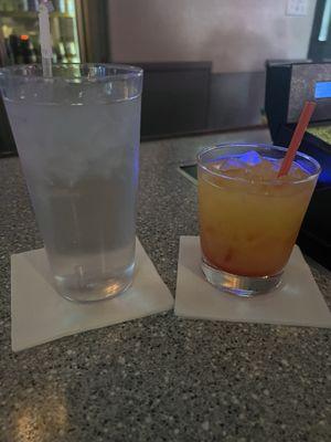 Glass of water and tequila sunrise