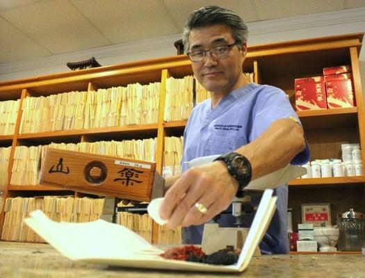 Here Dr. Chung measures out certain herbs for herbal tea. Each herbal tea is designed to help each patient's specific need.