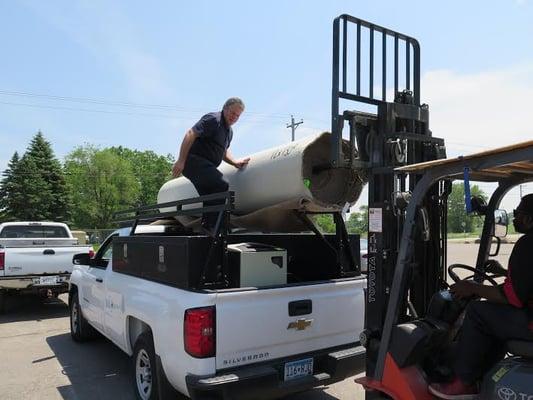 A roll of carpet being loaded at a recent Auction Masters auction.