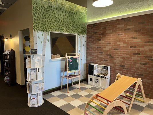 The cutest little play area with a kids kitchenette and a pilker triangle.