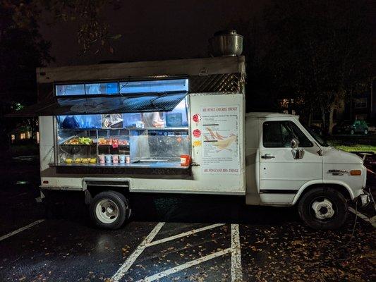 Outside the food truck. Passenger side. Ordering window and self-serve shelves.