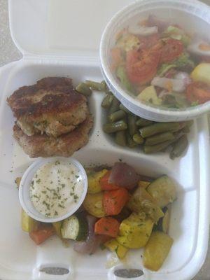 Fish cakes, vegetables (zucchini, squash, carrots, onions), green beans, and salad.