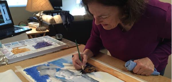 A student works on a watercolor of Shiprock, New Mexico.